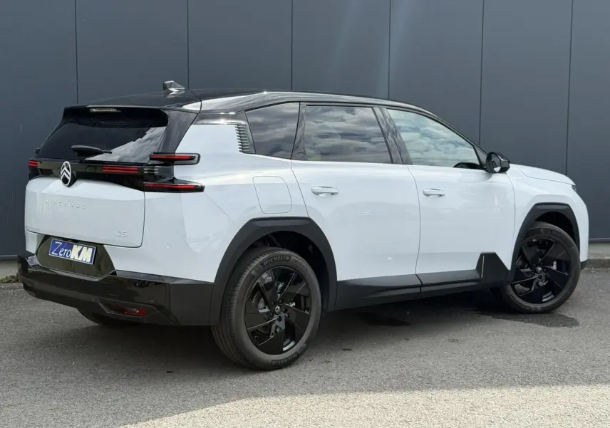 Vue 3/4 arrière droite d'un Citroën C5 Aircross blanc Okenite avec toit noir et jantes alliage noires.