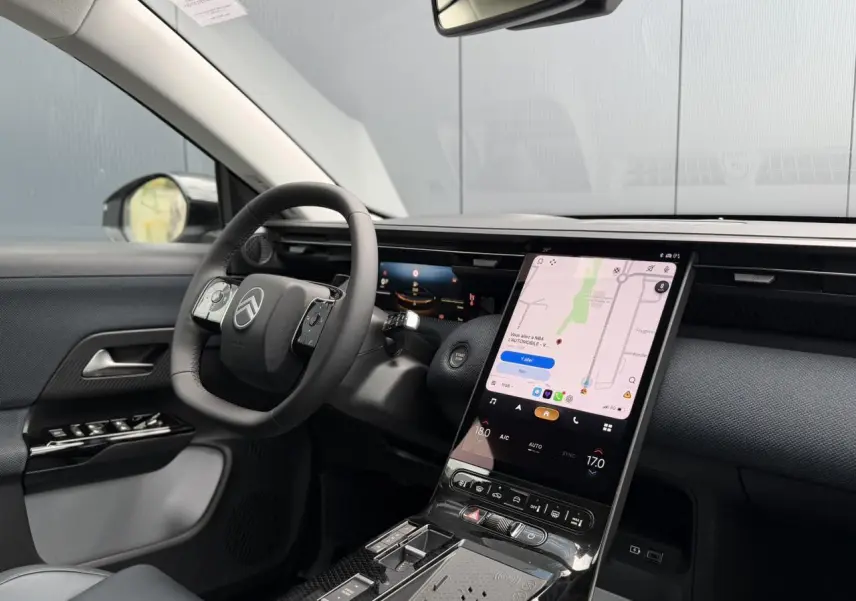 Vue intérieure côté conducteur du Citroën C5 Aircross blanc, avec grand écran tactile vertical et volant multifonctions noir.