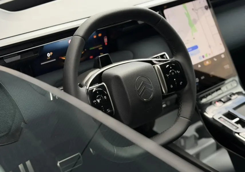 Vue rapprochée du volant noir mat et des écrans digitaux du tableau de bord du Citroën C5 Aircross hybride 2026.