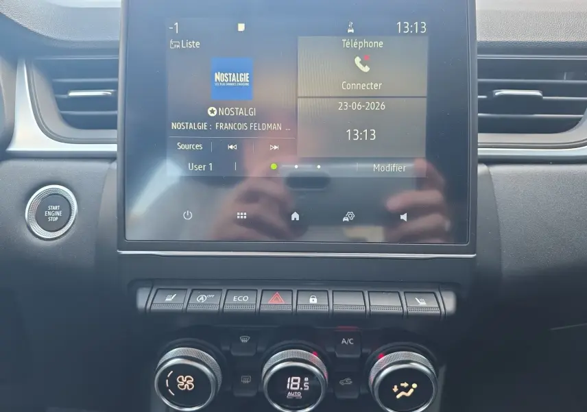Vue rapprochée de la console centrale du Renault Captur noir 2021, écran tactile et commandes climatisation visibles.