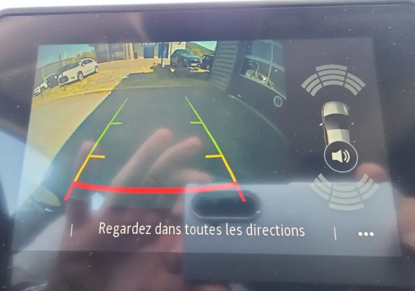Vue de l'écran de la caméra de recul du Renault Captur noir, avec lignes de guidage colorées et alertes de proximité.