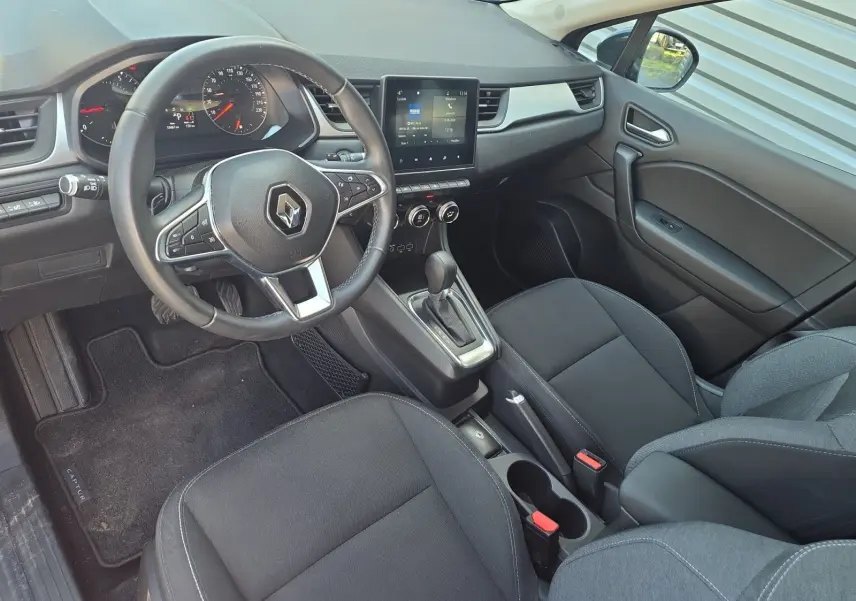 Intérieur noir de Renault Captur 2021 vu côté conducteur, avec volant multifonction et écran tactile central.