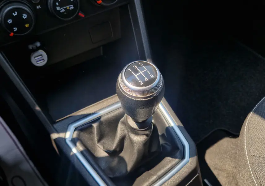 Le levier de vitesses manuel noir de la Dacia Sandero SCE 65 22 Confort, vu en gros plan intérieur.