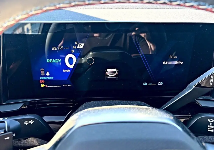 Vue rapprochée du tableau de bord numérique du Renault Austral 2026, affichage digital moderne avec indicateurs bleus et blancs.