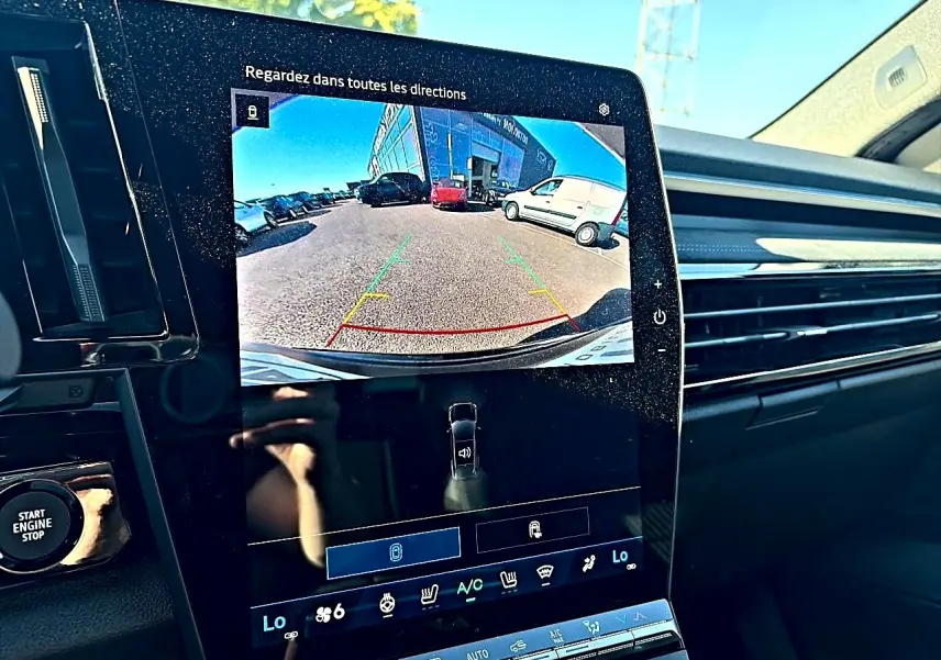 Écran tactile intérieur du Renault Austral noir montrant la caméra de recul avec vue arrière du parking.