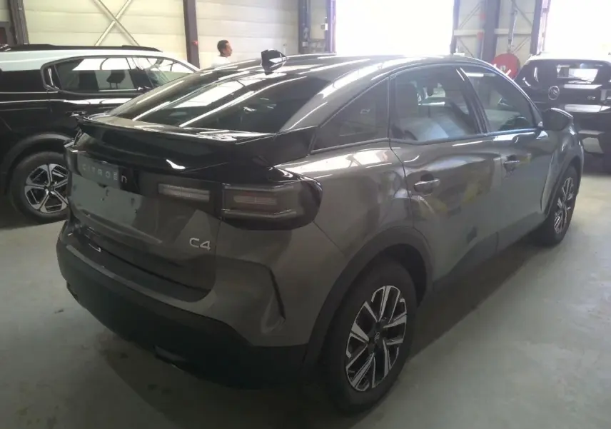 Vue 3/4 arrière droite d'une Citroën C4 hybride gris Mercury avec jantes bi-ton et feux arrière LED.