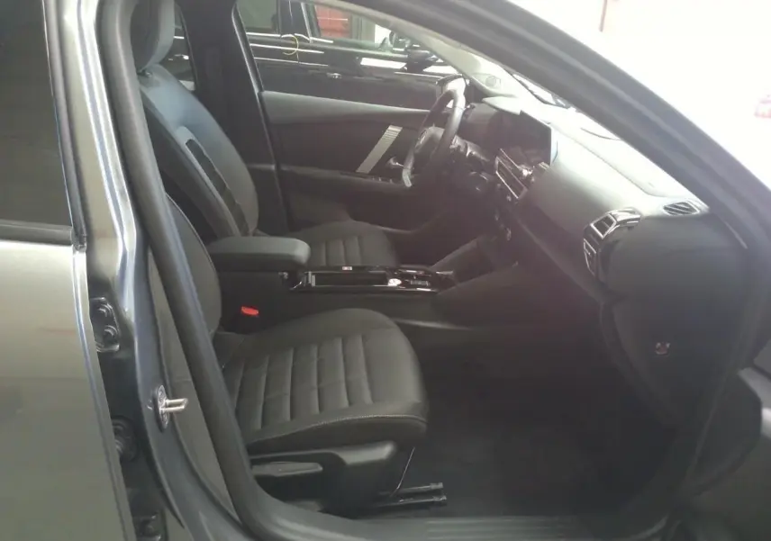 Intérieur avant droit de la Citroën C4 gris Mercury 2025, sièges noirs et tableau de bord moderne avec écran tactile.