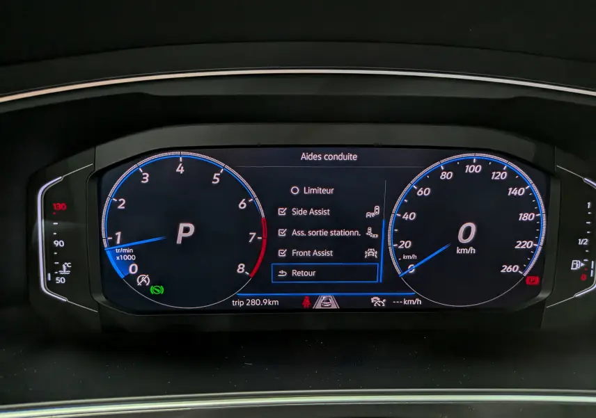 Vue rapprochée du tableau de bord numérique du Volkswagen Tiguan 2024 affichant les aides à la conduite activées.