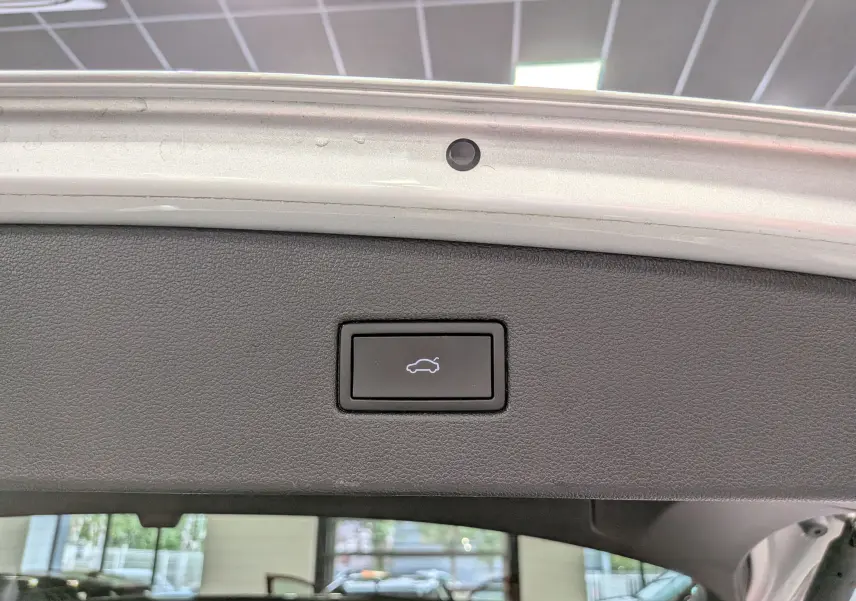 Bouton d'ouverture électrique du coffre sur la partie intérieure du hayon du Volkswagen Tiguan reflet d'argent 2024.