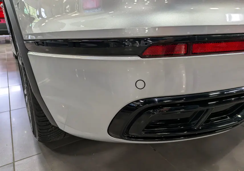 Gros plan sur le coin arrière droit du Volkswagen Tiguan 2024 reflet d'argent, avec feu arrière et sortie d'échappement noire.