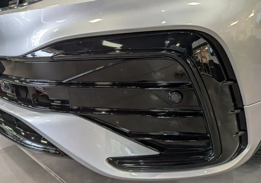 Gros plan sur la partie avant droite du Volkswagen Tiguan 2024 reflet d'argent, mettant en valeur la calandre noire brillante.