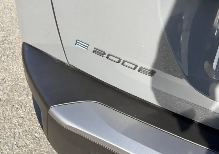 Détail du logo e-2008 sur le coffre arrière gris Artense avec pare-chocs noir, vue en gros plan côté droit.