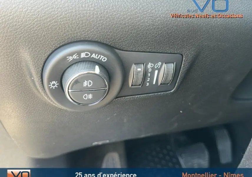 Gros plan sur les commandes d'allumage automatique des feux et réglage d'intensité lumineuse du Jeep Compass noir 2023.