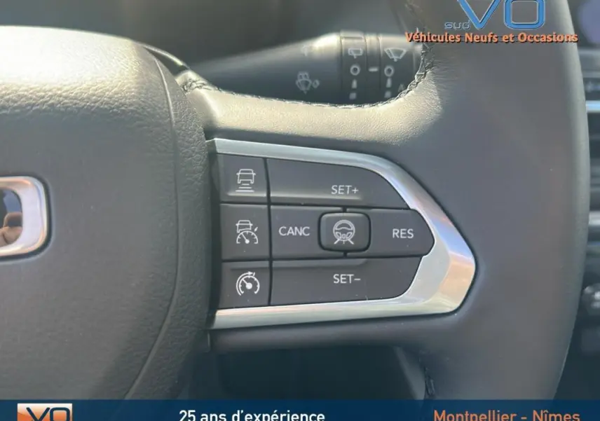 Gros plan sur les commandes du régulateur de vitesse au volant cuir du Jeep Compass noir 2023.