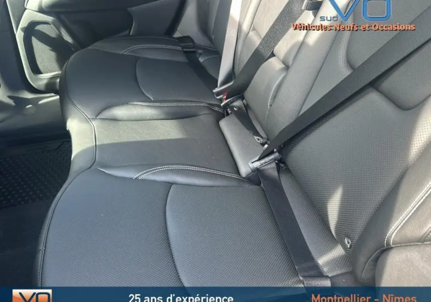 Vue rapprochée des sièges arrière en cuir noir du Jeep Compass 2023, mettant en valeur les ceintures de sécurité et les finitions soignées.