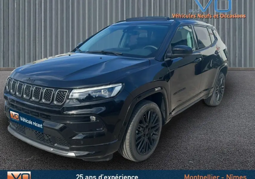 Jeep Compass noir en 3/4 avant droit, avec jantes alliage noires et toit ouvrant panoramique visible.
