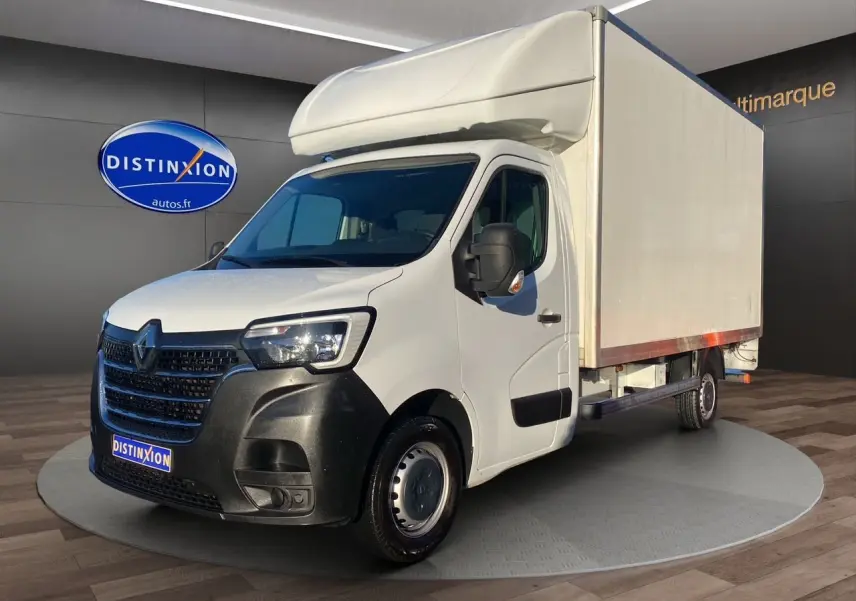 Renault Master blanc en 3/4 avant droit avec caisse hayon, calandre noire et jantes tôlées 16 pouces visibles.