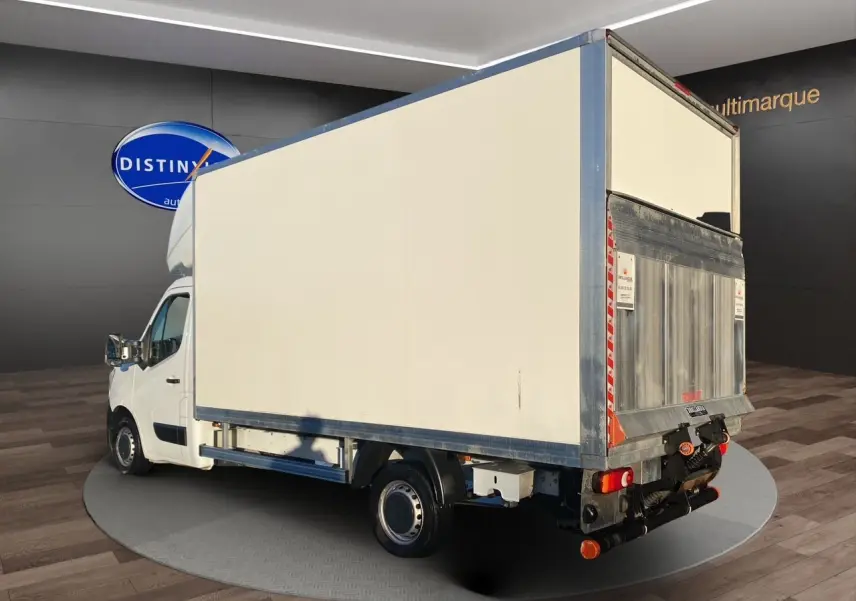 Renault Master blanc vu en 3/4 arrière droit avec caisse fermée et hayon élévateur métallique visible.