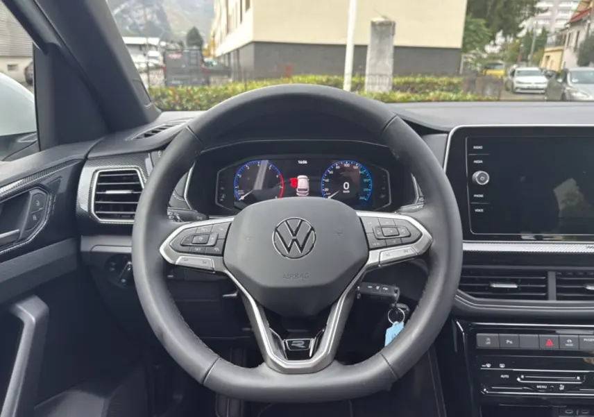 Volant cuir multifonctions Volkswagen T-Cross TSI 116 DSG7 R-Line vu de face avec tableau de bord numérique allumé.