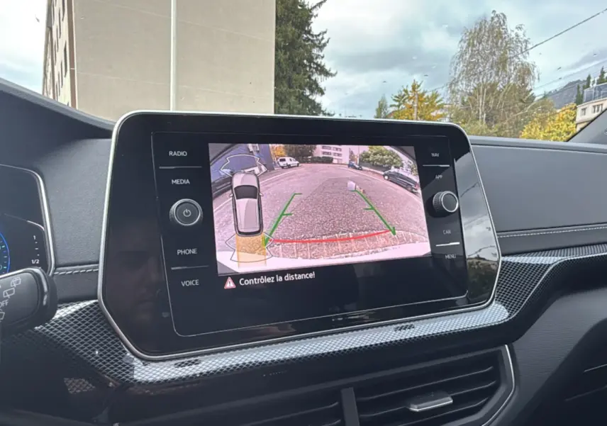 Écran central du Volkswagen T-Cross blanc pur 2025 affichant la caméra de recul avec guidage dynamique.