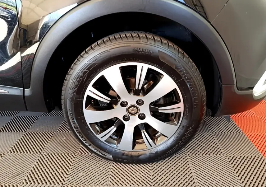 Gros plan sur la roue avant droite noire du Renault Captur Business TCe 90 de 2018 avec jante alliage.