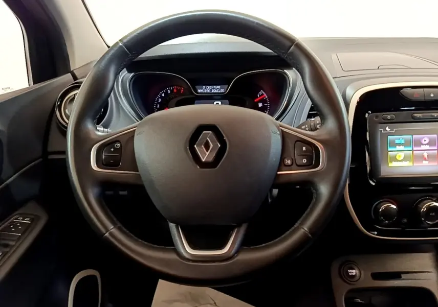 Vue intérieure centrée sur le volant cuir noir de la Renault Captur Business 2018 avec tableau de bord et écran tactile.