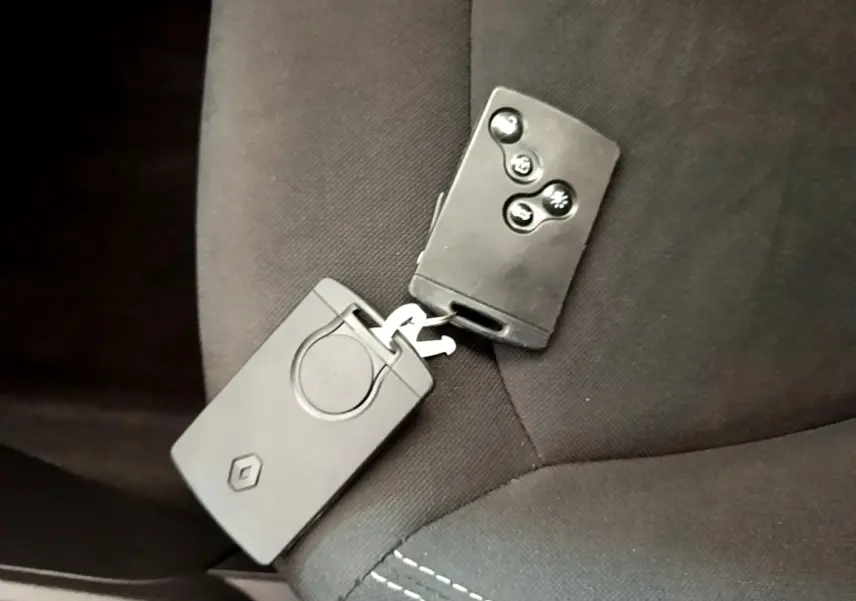 Clé de voiture Renault Captur Business TCe 90 noire posée sur un siège tissu noir à coutures visibles.