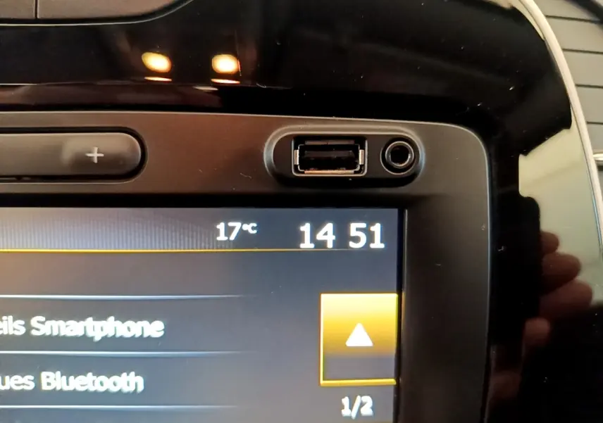 Gros plan sur l'écran tactile noir du tableau de bord du Renault Captur Business TCe 90, affichant l'heure et la température.