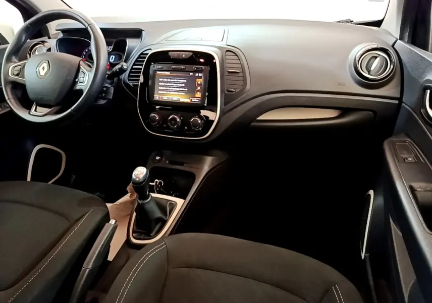 Vue intérieure avant du Renault Captur Business TCe 90 2018 noir, avec tableau de bord tactile et boîte manuelle.