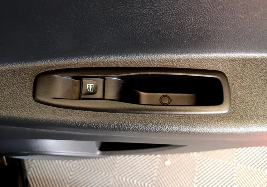 Détail de la commande de lève-vitre électrique côté porte intérieure d’un Renault Captur Business noir de 2018.