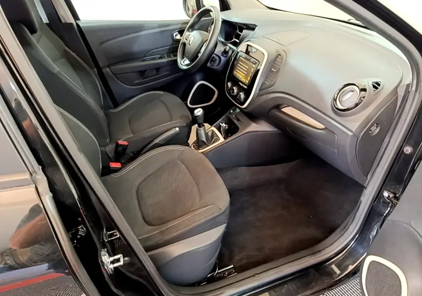 Intérieur avant droit de la Renault Captur Business TCe 90 noir, montrant sièges, volant cuir et tableau de bord tactile.