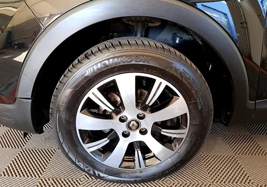 Gros plan sur la roue avant droite noire du Renault Captur Business TCe 90 avec jante alliage argentée.