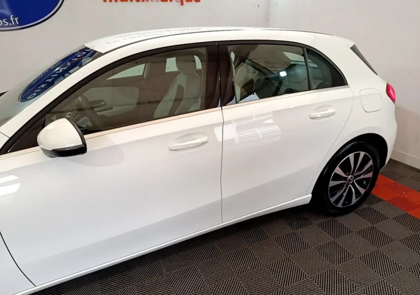 Vue latérale droite d'une Mercedes Classe A Berline blanche, avec rétroviseur électrique et jantes alliage distinctives.