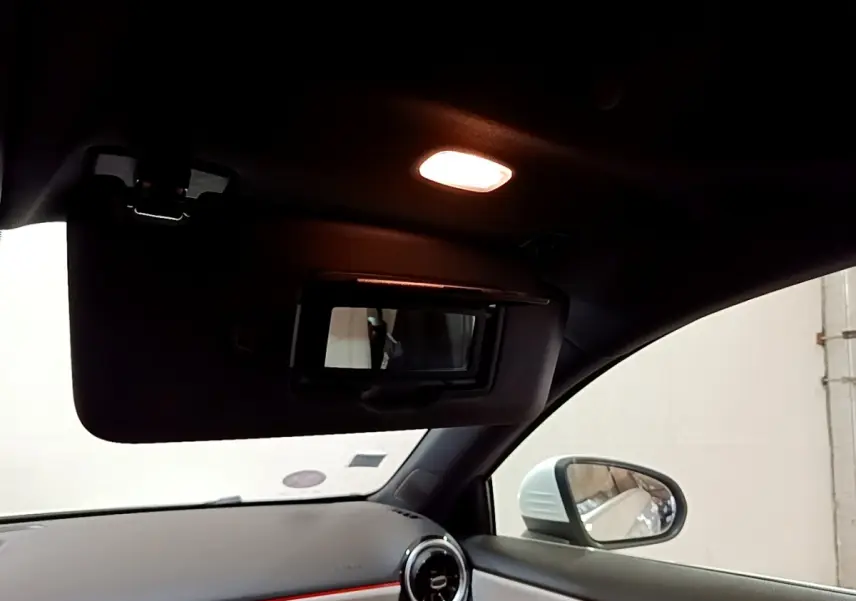 Intérieur de la Mercedes Classe A blanche, vue côté droit sur pare-soleil avec miroir éclairé et rétroviseur extérieur.