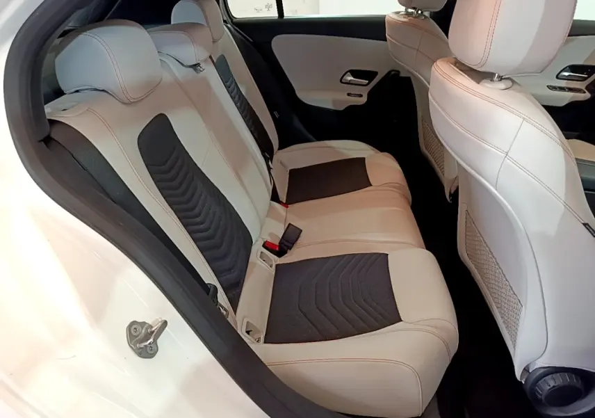 Vue intérieure côté droit des sièges arrière en cuir beige et noir de la Mercedes Classe A Berline A 250 e Business Line blanche.