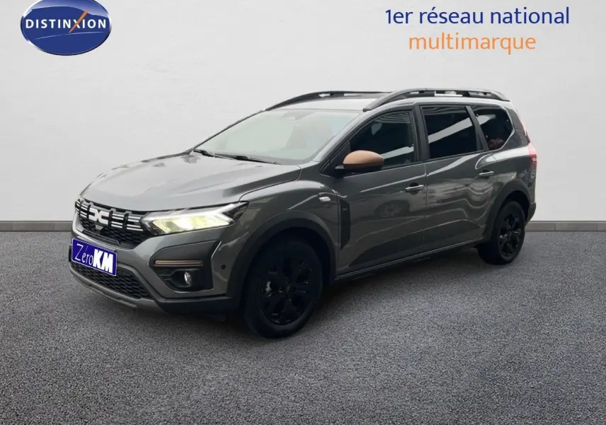 Dacia Jogger gris schiste métal en 3/4 avant droit avec jantes noires et rétroviseurs couleur cuivre.