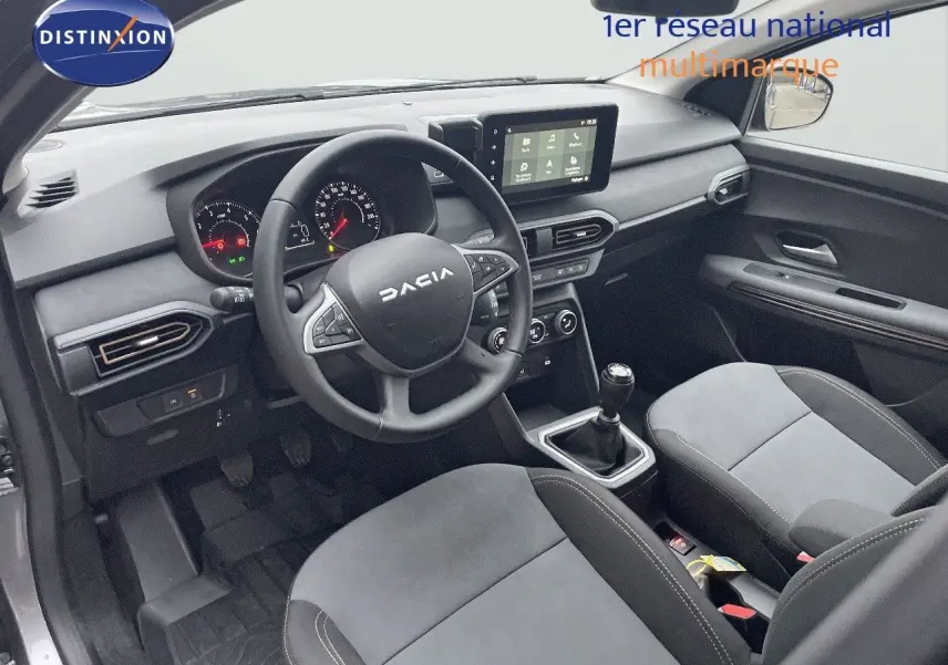 Vue latérale droite du Dacia Jogger gris schiste métal avec jantes noires et barres de toit, sur fond neutre.