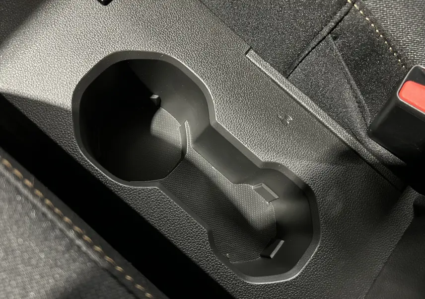 Gros plan sur le porte-gobelets noir entre les sièges en tissu noir du Dacia Jogger gris schiste métal.