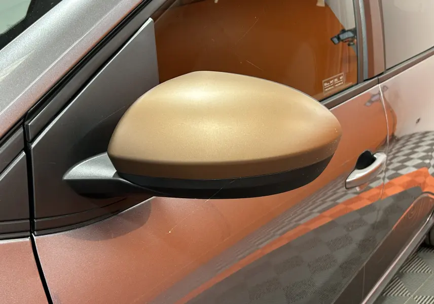 Gros plan sur le rétroviseur côté gauche gris doré du Dacia Jogger gris schiste métal avec poignée de porte visible.