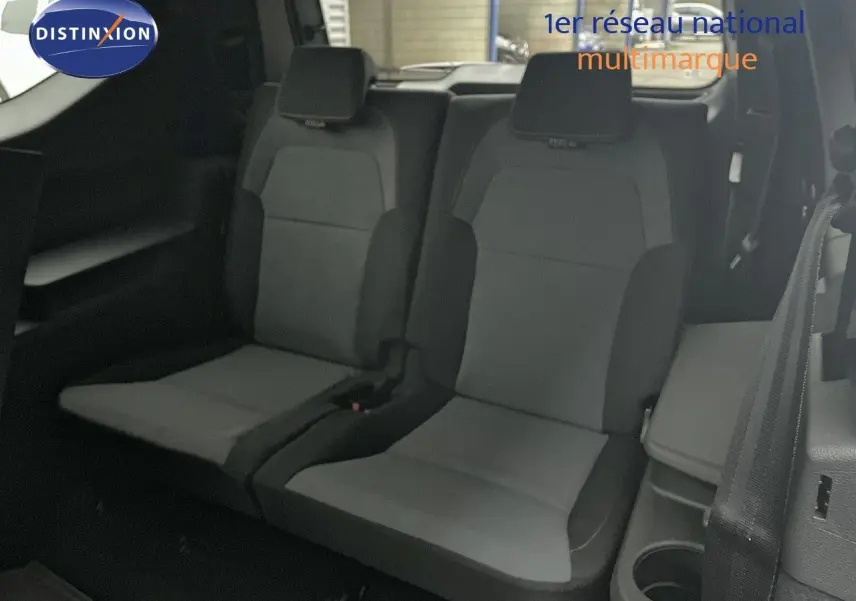 Vue 3/4 arrière droite d'un Dacia Jogger gris schiste métallisé avec feux arrière allumés sur fond neutre.