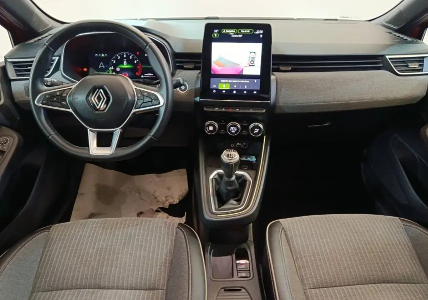 Vue intérieure avant de la Renault Clio Techno TCe 90 2024, tableau de bord avec écran tactile vertical et boîte manuelle.