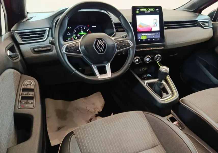 Vue intérieure avant de la Renault Clio Techno TCe 90 2024, volant multifonctions, écran tactile vertical et levier de vitesse manuel.