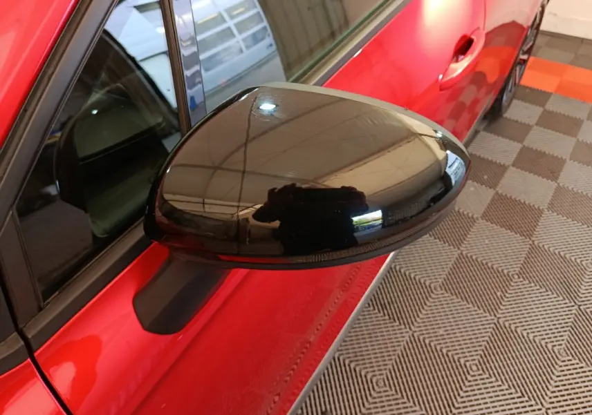 Rétroviseur droit noir en gros plan sur Renault Clio Techno TCe 90 rouge, vue côté droit avant.