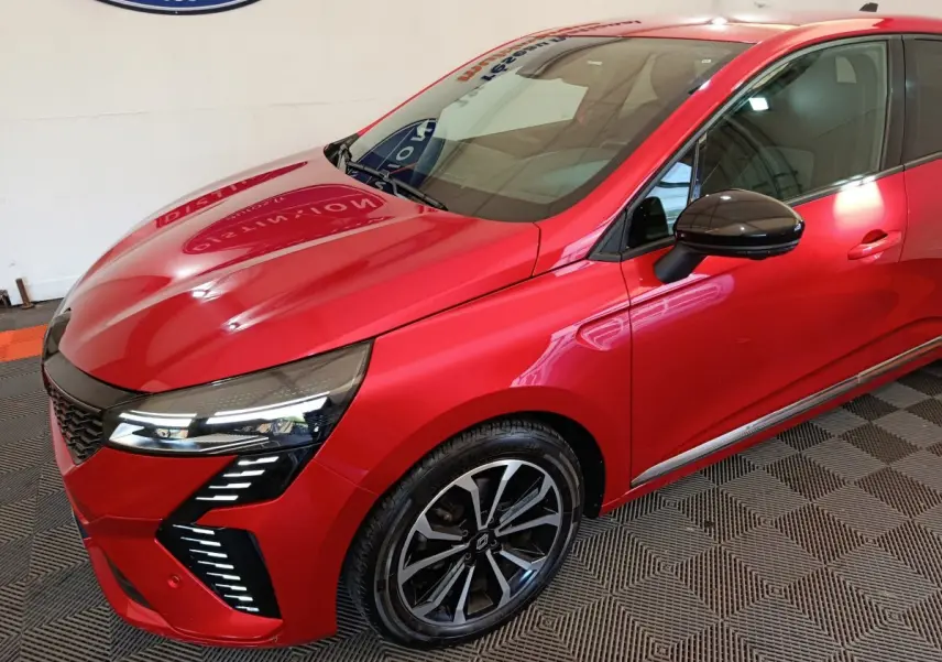 Vue 3/4 avant droite d'une Renault Clio Techno TCe 90 rouge avec phares LED et jantes alliage noires.