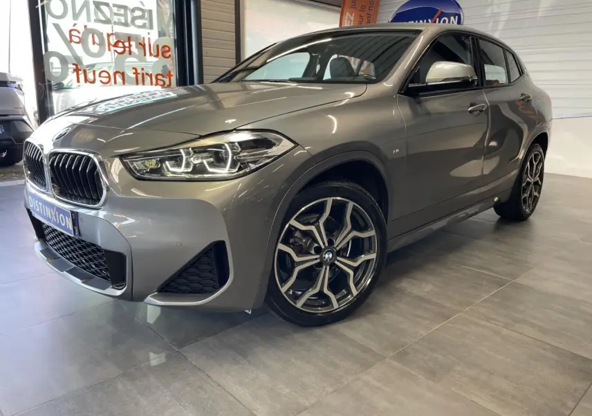 BMW X2 sDrive 18d M Sport X gris foncé vue 3/4 avant droit avec jantes 19 pouces style 722 M à rayons en Y.