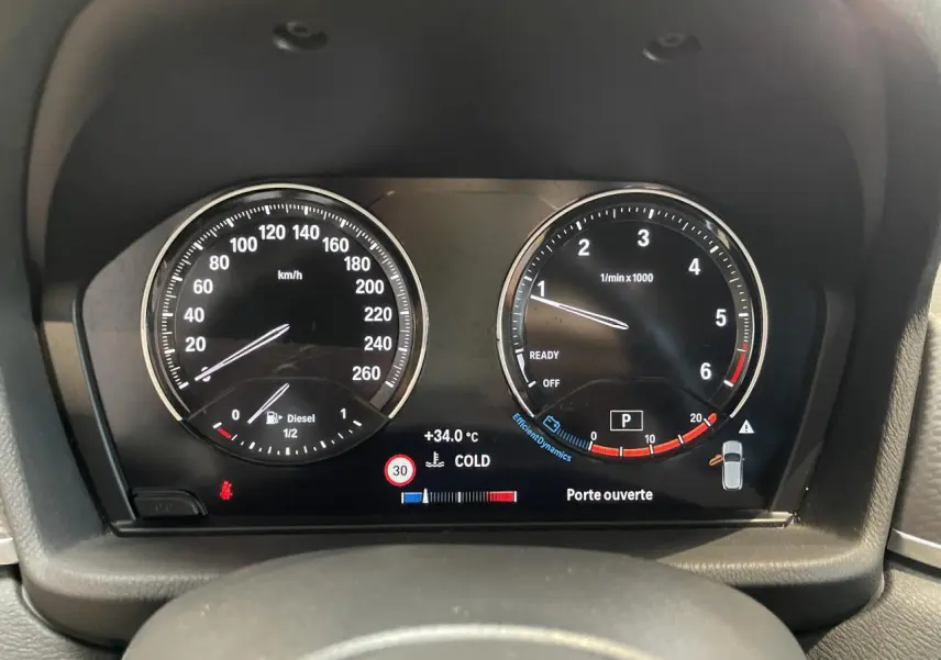 Vue rapprochée du tableau de bord numérique de la BMW X2 gris foncé, affichant compte-tours et vitesse en km/h.