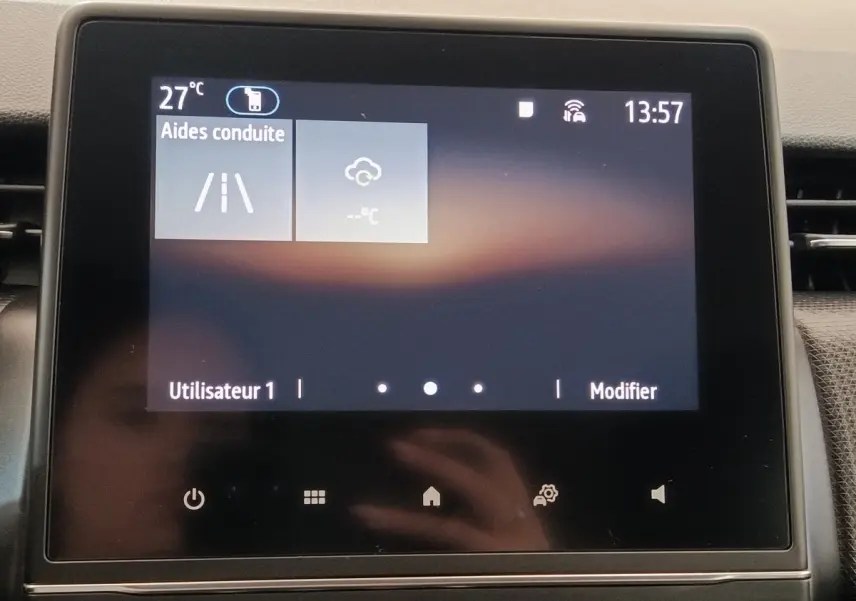 Écran tactile central affichant les aides à la conduite dans l’habitacle de la Renault Clio Business blanc.