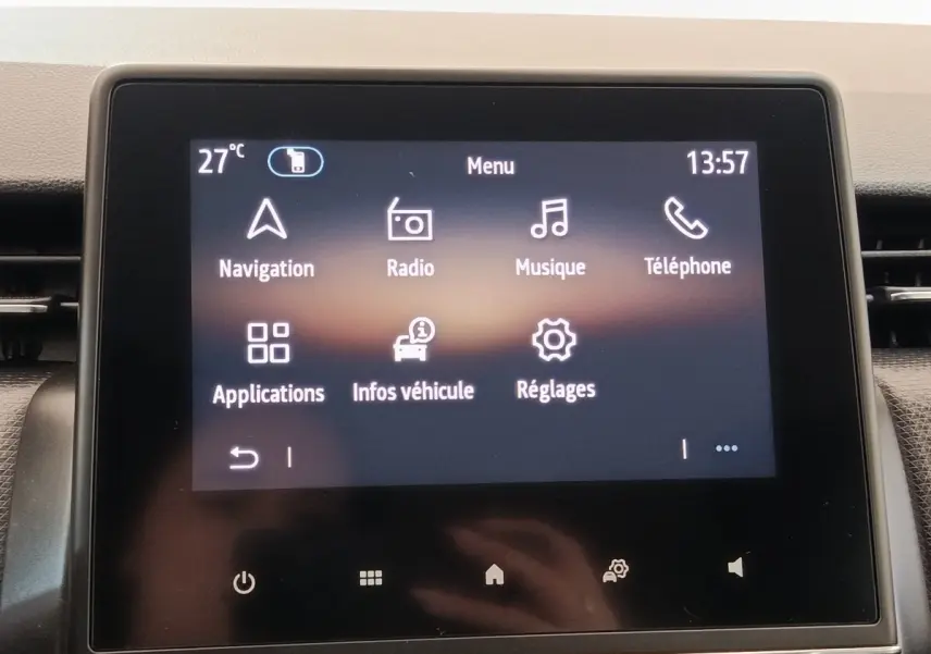 Écran tactile central de la Renault Clio Business blanc, affichant le menu principal avec options navigation et radio.