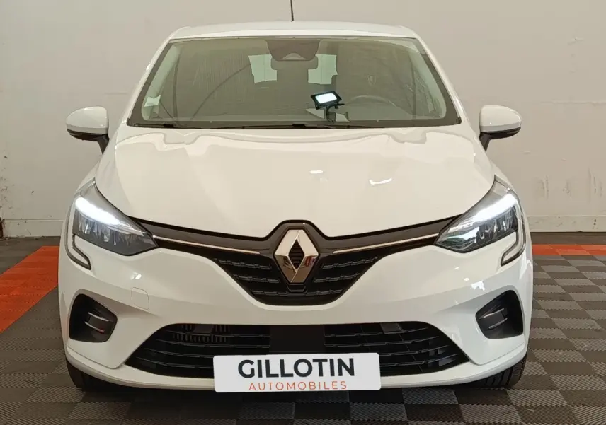 Vue avant d'une Renault Clio Business blanche avec phares LED allumés et calandre noire brillante.