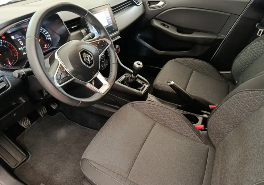 Vue intérieure côté conducteur de la Renault Clio Business TCe 100 GPL 2021, volant cuir et sièges tissu gris.